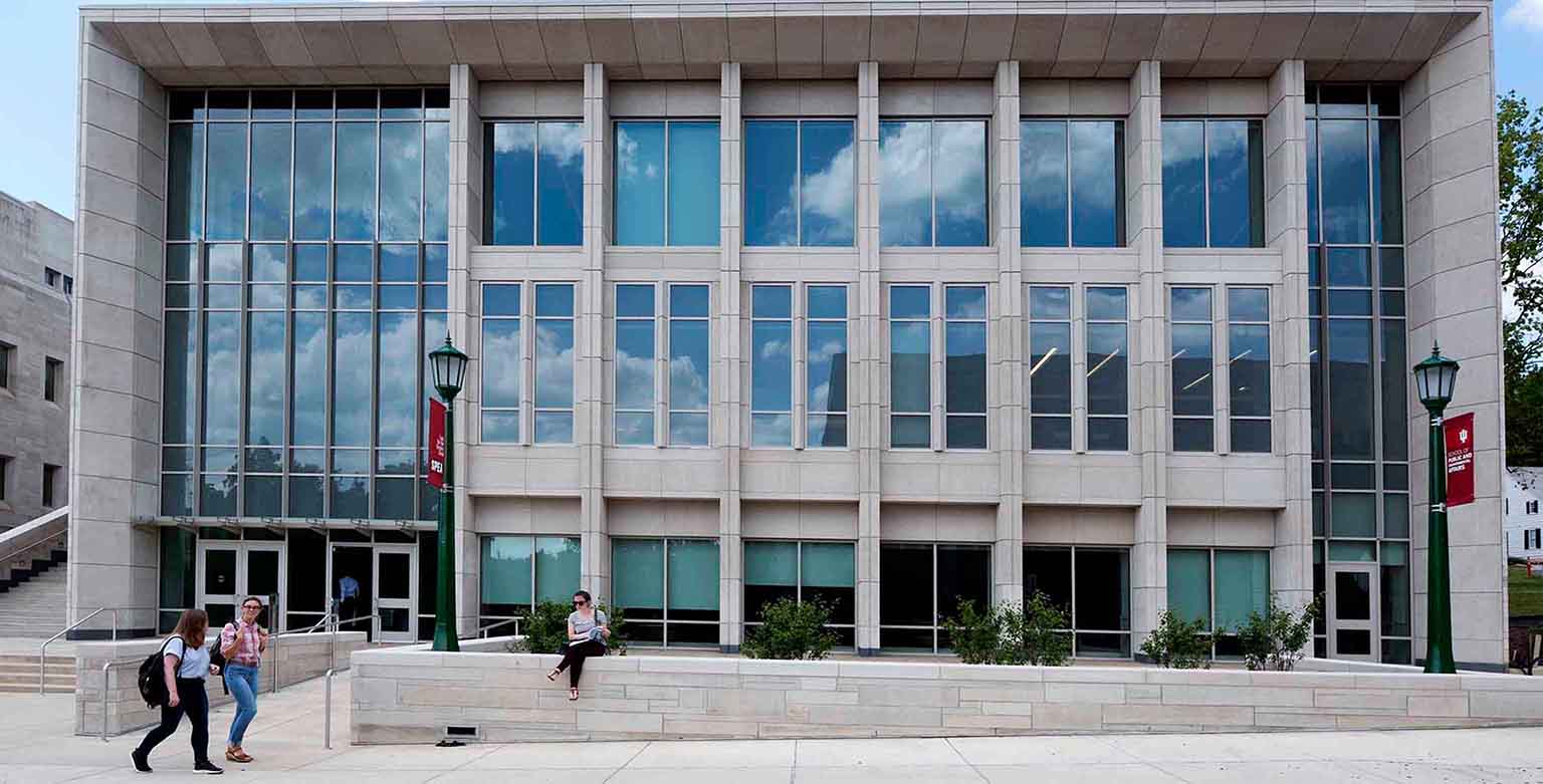 Students walk in front of the O'Neill building on a sunny day.