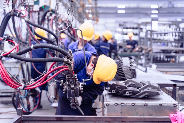 Workers on a modern auto assembly line