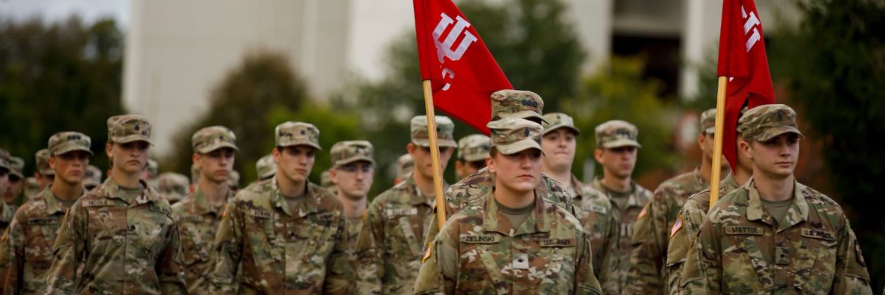 A group in camo with IU flags marches in a parade
